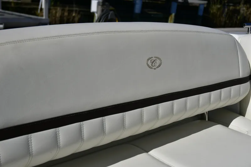 Slide: The Image of White leather seating in a 2016 Cobalt 336 boat, featuring elegant stitching and logo. - 12