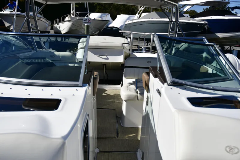 Slide: The Image of 2016 Cobalt 336 boat interior with seating and glass windshields, docked among other boats. - 15