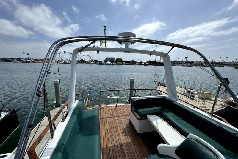 Slide: The Image of 1985 PT Boats PT 38 Aft Cabin with green seating, docked in a marina. - 11