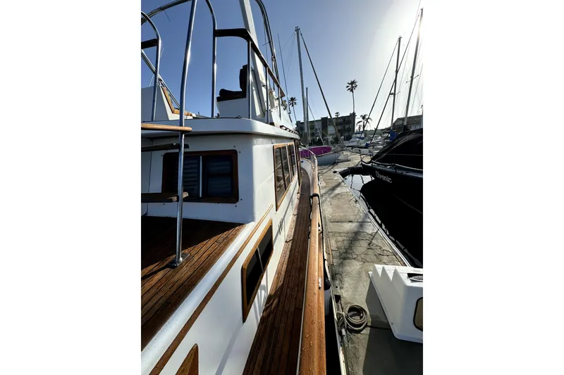 Slide: The Image of 1985 PT Boats PT 38 Aft Cabin docked, showcasing wooden deck and marina view. - 5