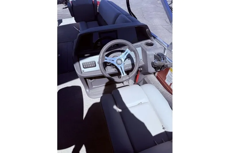 Slide: The Image of Interior view of 2026 Sun Tracker Sportfish 24 XP3 boat, featuring steering wheel and seating. - 4