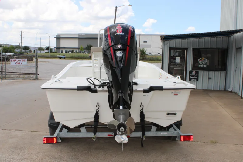 Slide: The Image of 2026 Mako Pro Skiff 19 CC boat on trailer, rear view, outside service area. - 3