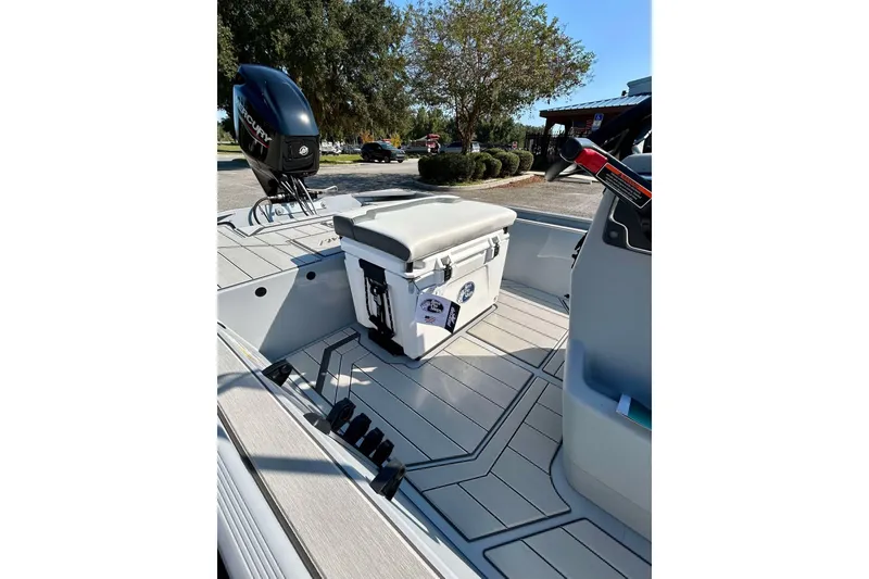 Slide: The Image of 2026 Tracker Bass Tracker Classic CC boat interior with seating and motor, parked outdoors. - 10