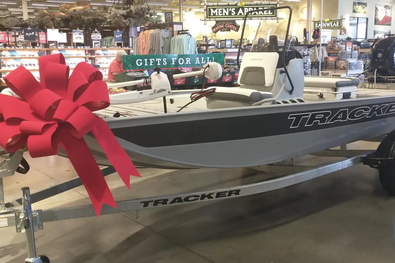 The Image of 2026 Tracker Bass Tracker Classic CC boat with red bow, displayed in a store. - 0