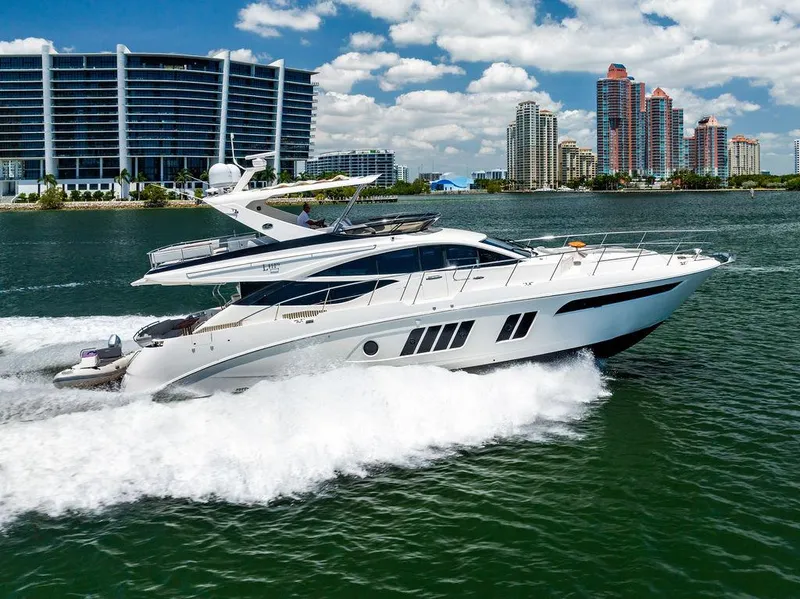 The Image of 2016 Sea Ray L650 Fly yacht cruising on water with city skyline in background. - 0