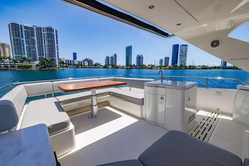 Slide: The Image of Luxurious 2016 Sea Ray L650 Fly yacht with city skyline view, featuring spacious deck seating. - 12