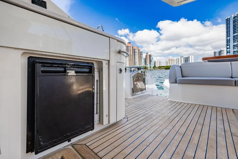 Slide: The Image of 2016 Sea Ray L650 Fly yacht deck with seating, city skyline, and blue sky. - 42