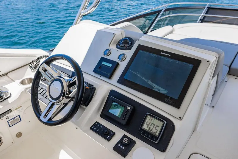 Slide: The Image of 2016 Sea Ray L650 Flybridge helm with modern navigation instruments and steering wheel. - 48