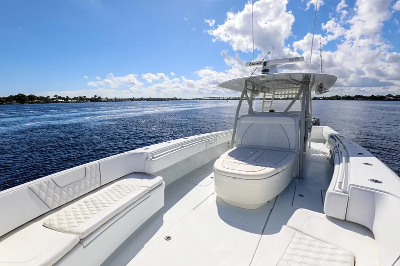 Slide: The Image of 2023 Contender 44 ST boat on open water under a clear blue sky. - 14