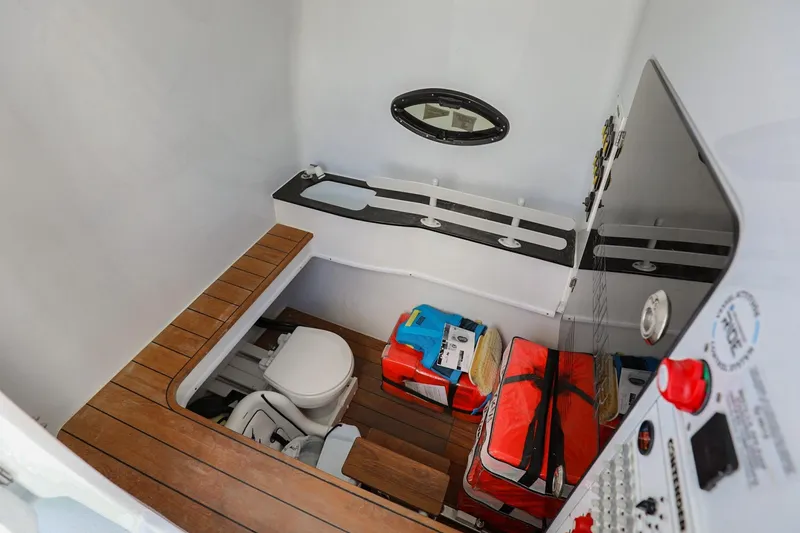 Slide: The Image of 2023 Contender 44 ST boat interior with toilet, storage, and control panel. - 28