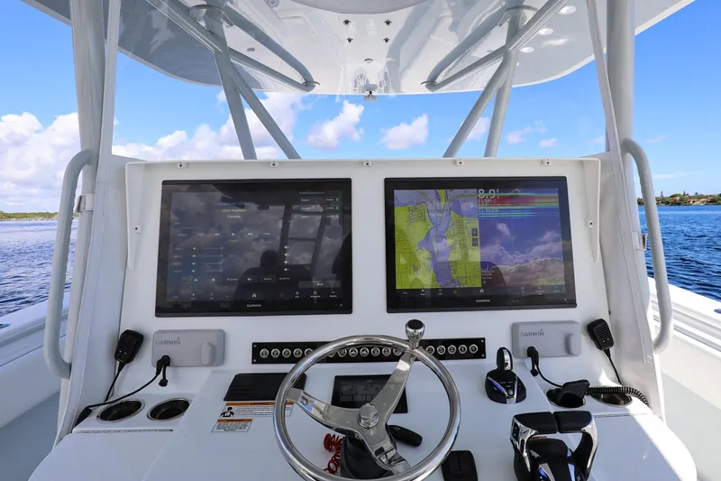 Slide: The Image of 2023 Contender 44 ST boat dashboard with dual Garmin displays and steering wheel. - 9