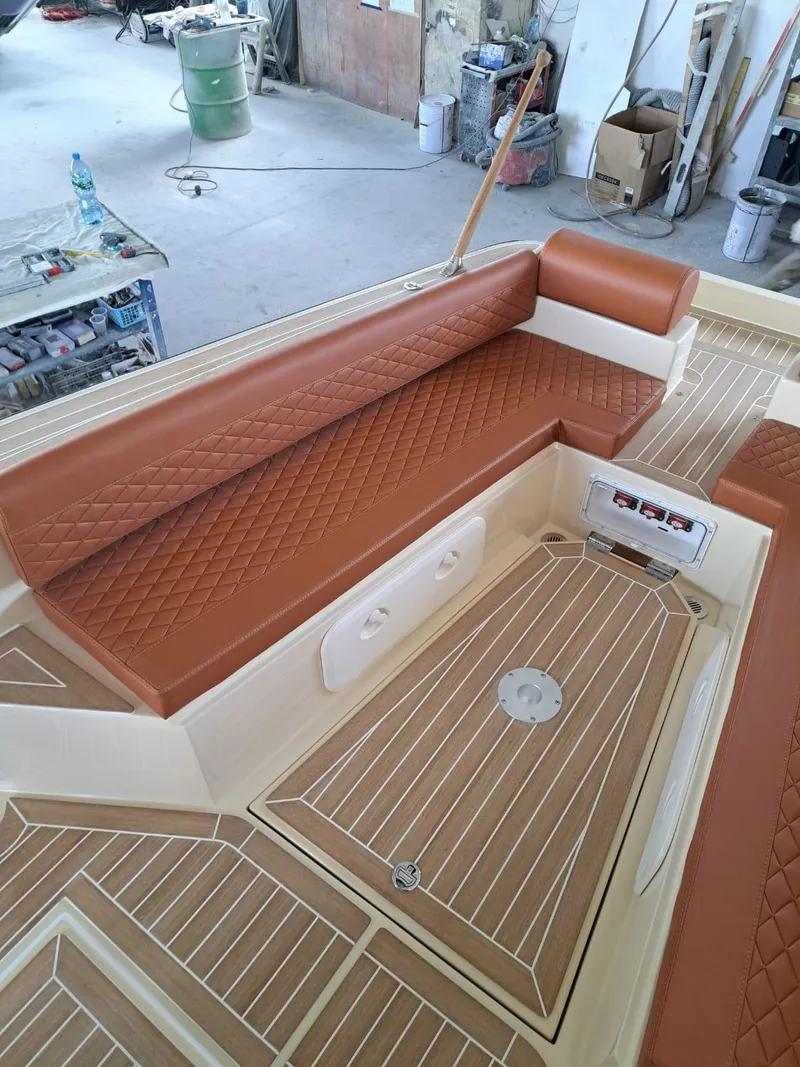 Slide: The Image of 2025 Lilybaeum Levanzo 25 Lounge Deck with brown quilted seating and wood-patterned flooring. - 24