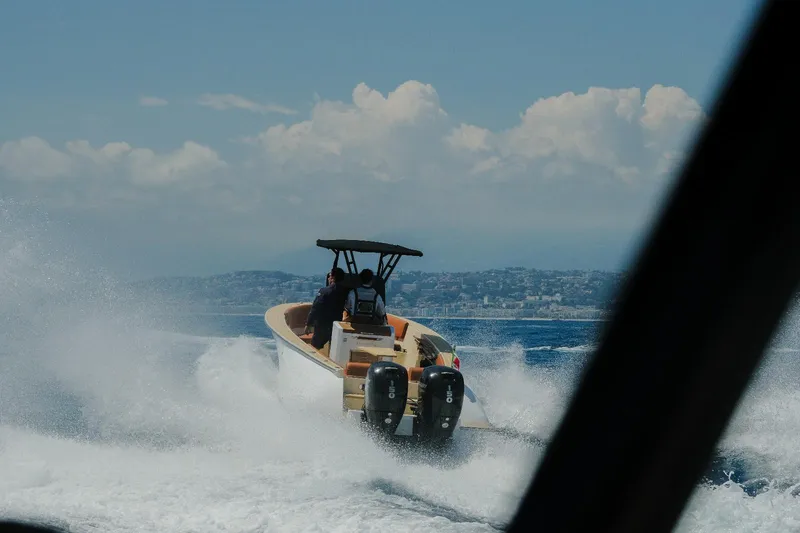 Slide: The Image of 2025 Lilybaeum Levanzo 25 Lounge Deck boat cruising on open water, creating waves. - 30