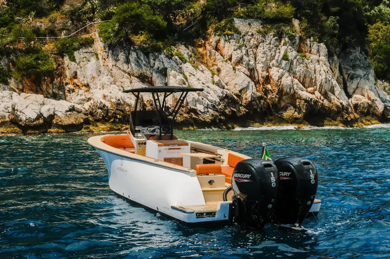 Slide: The Image of 2025 Lilybaeum Levanzo 25 Lounge Deck boat on clear water near rocky shoreline. - 8