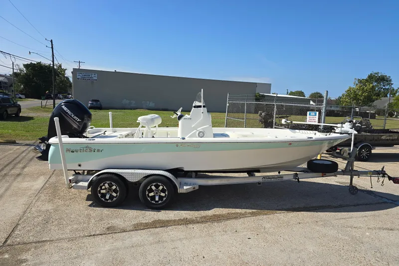 Slide: The Image of 2014 NauticStar 214 XTS Shallow Bay boat on trailer, parked outdoors. - 3
