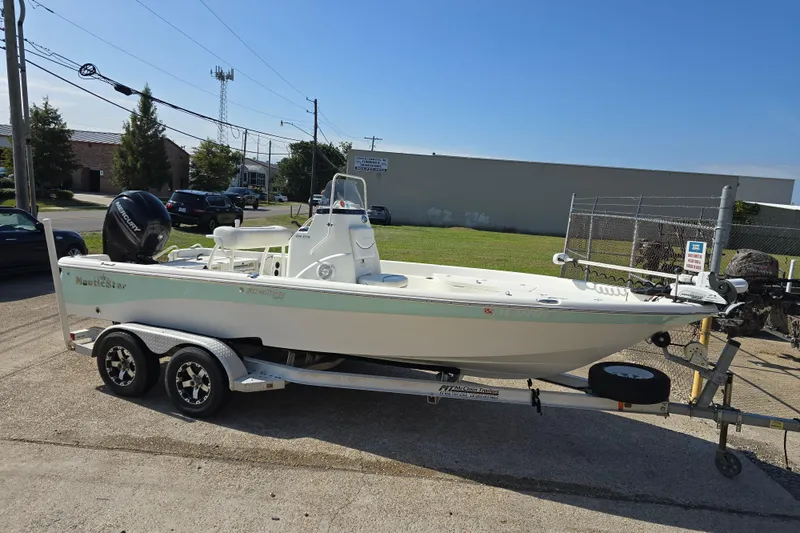 Slide: The Image of 2014 NauticStar 214 XTS Shallow Bay boat on trailer, parked outdoors. - 4