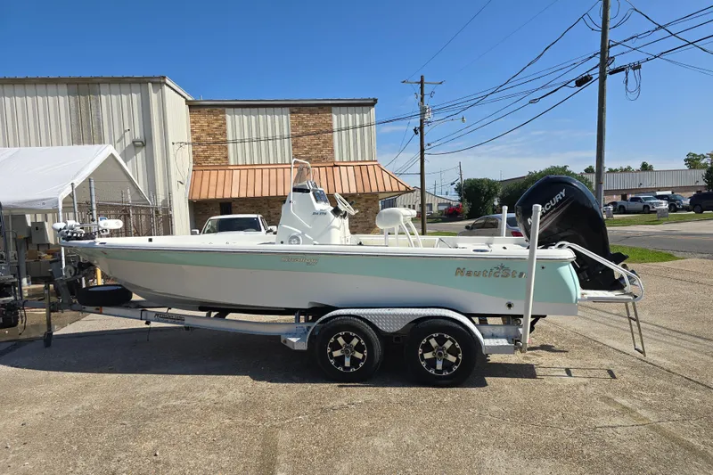 Slide: The Image of 2014 NauticStar 214 XTS Shallow Bay boat on trailer, parked outdoors. - 8