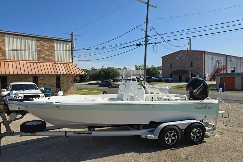 Slide: The Image of 2014 NauticStar 214 XTS Shallow Bay boat on trailer, parked outdoors. - 9