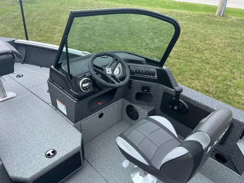 Slide: The Image of 2026 Lund 1775 Impact XS Sport boat interior with steering wheel and seating. - 10