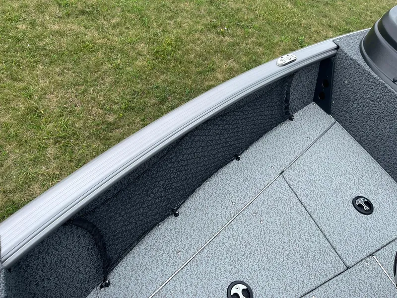 Slide: The Image of 2026 Lund 1775 Impact XS Sport boat interior with gray textured flooring and storage compartments. - 17