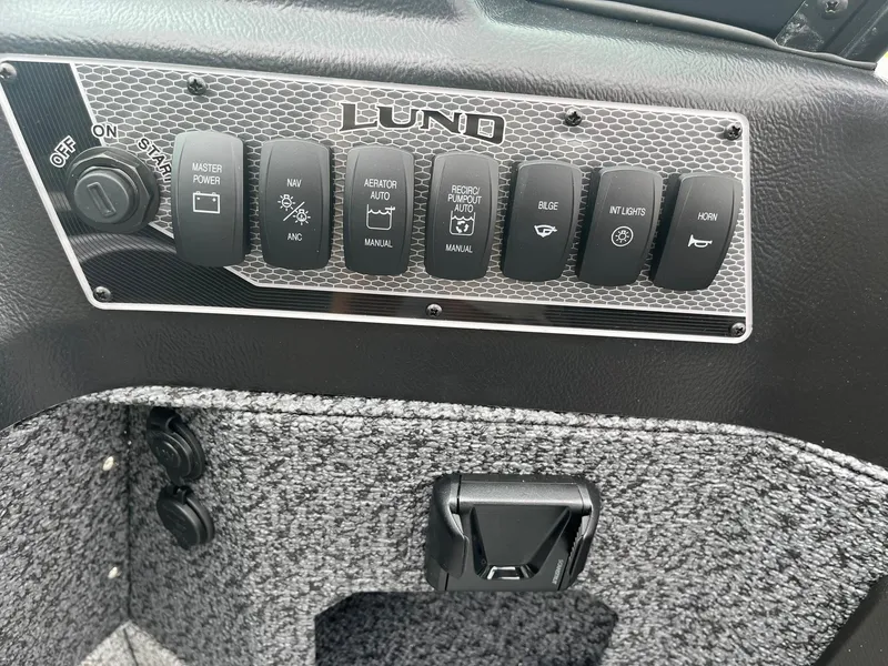 Slide: The Image of Control panel of 2026 Lund 1775 Impact XS Sport boat with various switches. - 22