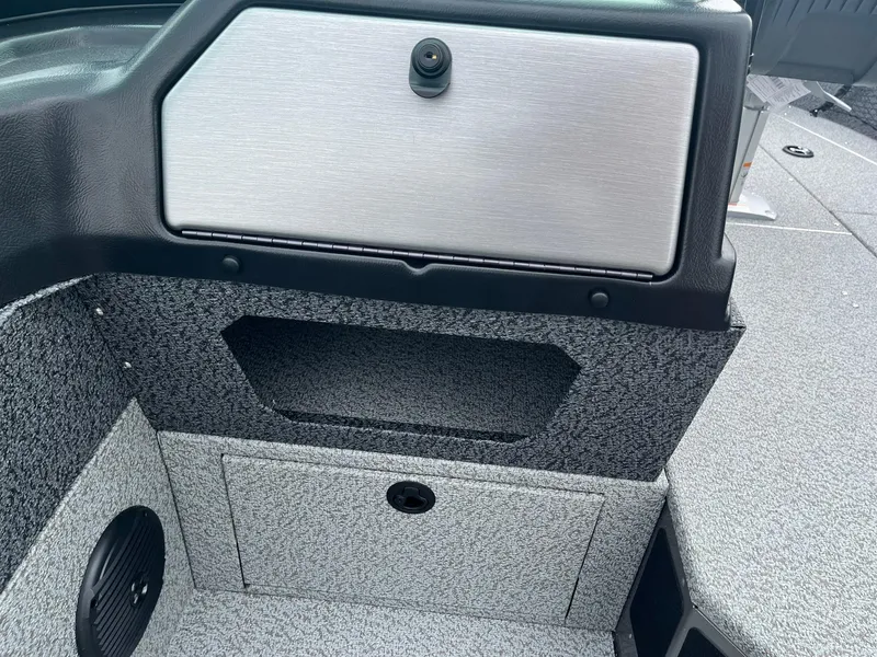 Slide: The Image of Interior of 2026 Lund 1775 Impact XS Sport boat, featuring storage compartments and speaker. - 25