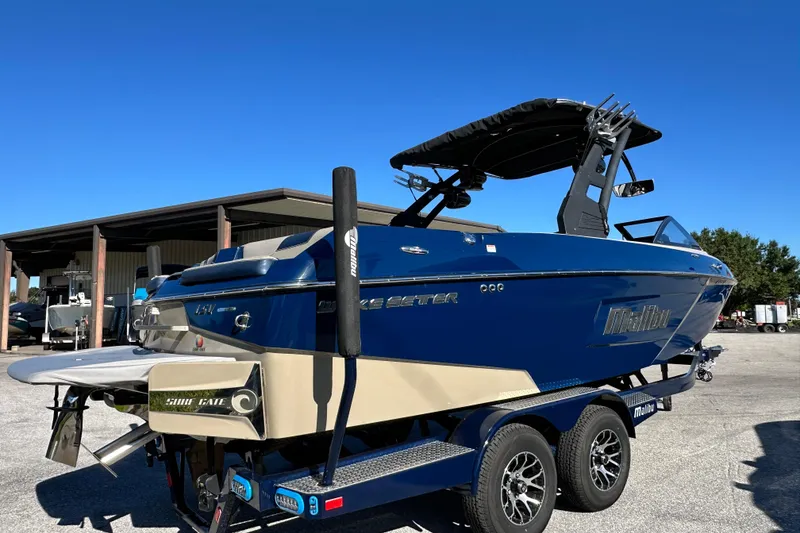 Slide: The Image of 2018 Malibu Wakesetter 23 LSV boat on trailer under clear blue sky. - 2