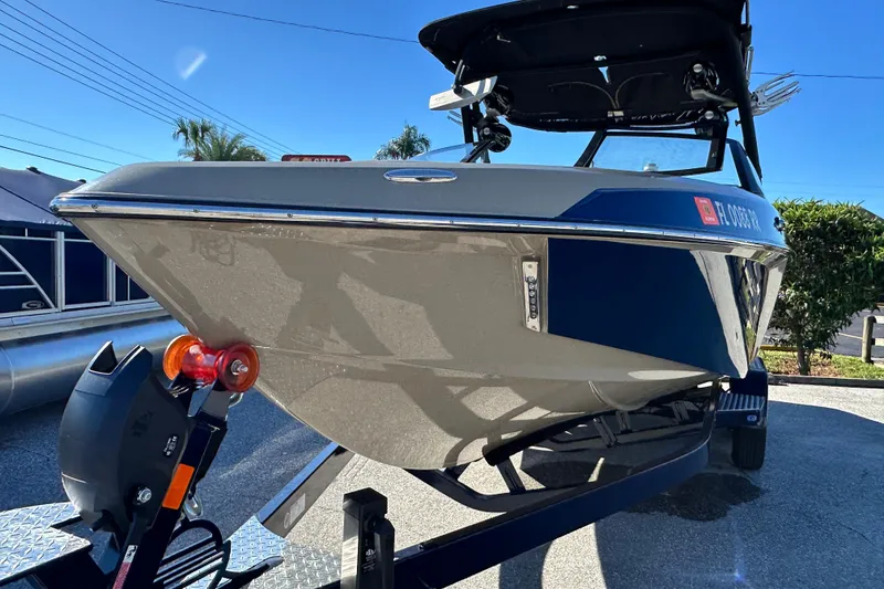 Slide: The Image of 2018 Malibu Wakesetter 23 LSV boat on trailer, sunny day, blue and white design. - 8