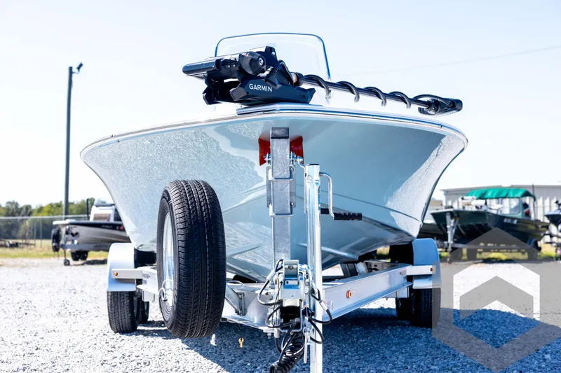 Slide: The Image of 2026 Tidewater 2110 Bay Max boat on trailer, featuring Garmin equipment, parked outdoors. - 2