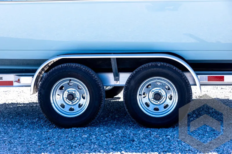 Slide: The Image of 2026 Tidewater 2110 Bay Max trailer wheels on gravel surface. - 28