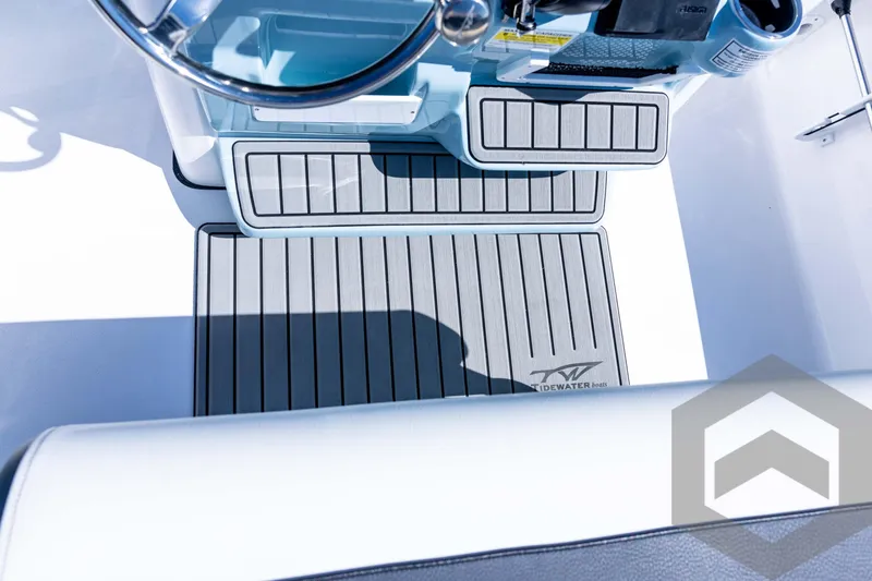 Slide: The Image of 2026 Tidewater 2110 Bay Max boat interior with steering wheel and branded flooring. - 59