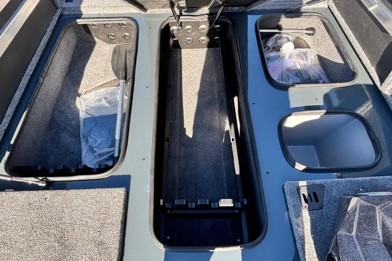 Slide: The Image of 2026 Ranger RT198P boat storage compartments with carpeted interiors and organized layout. - 5