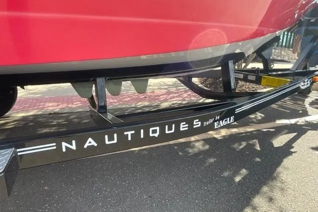 Slide: The Image of 2009 Nautique Ski Nautique 196 on trailer, showcasing sleek red hull design. - 10