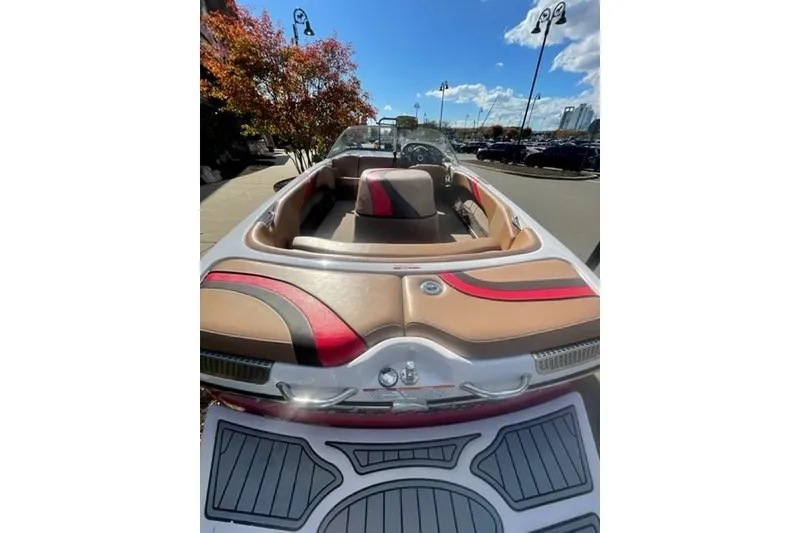 Slide: The Image of 2009 Nautique Ski Nautique 196 boat with stylish interior, parked outdoors under a clear sky. - 20