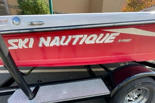 Slide: The Image of 2009 Nautique Ski Nautique 196 boat with red and white design on trailer. - 24