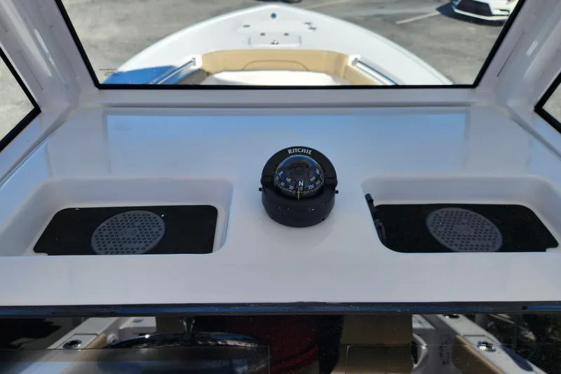 Slide: The Image of 2026 Sportsman Masters 247OE Bay Boat dashboard with compass and storage compartments. - 17