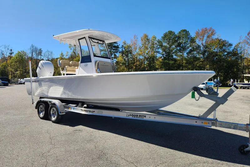 Slide: The Image of 2026 Sportsman Masters 247OE Bay Boat on trailer, parked outdoors under clear blue sky. - 7