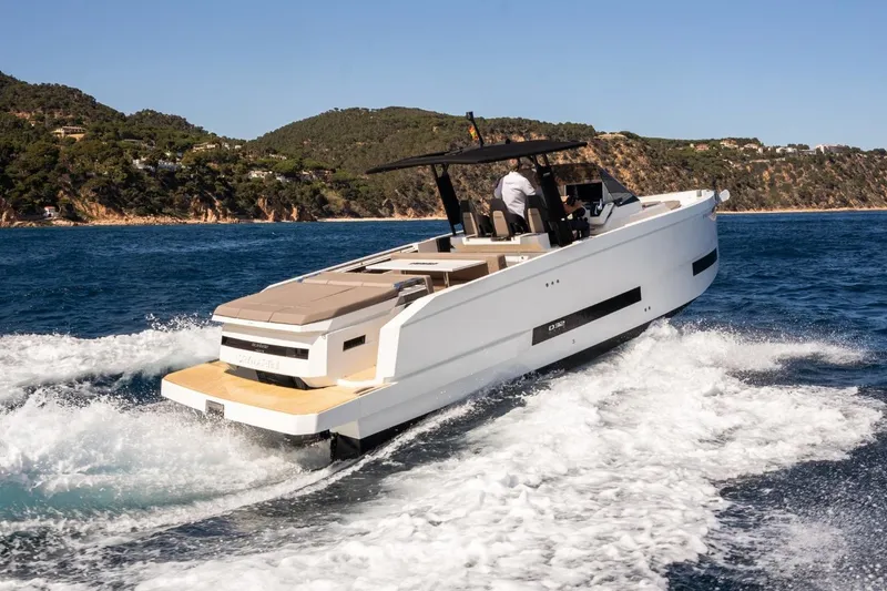 Slide: The Image of 2026 De Antonio Yachts D32 cruising on blue ocean near scenic coastline. - 4