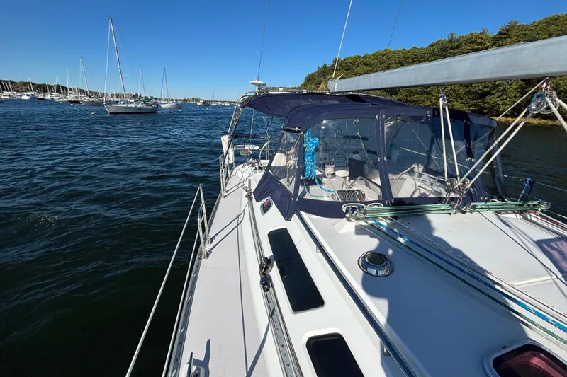Slide: The Image of 2004 Catalina 400 MkII sailboat on calm water, surrounded by other boats and lush greenery. - 23