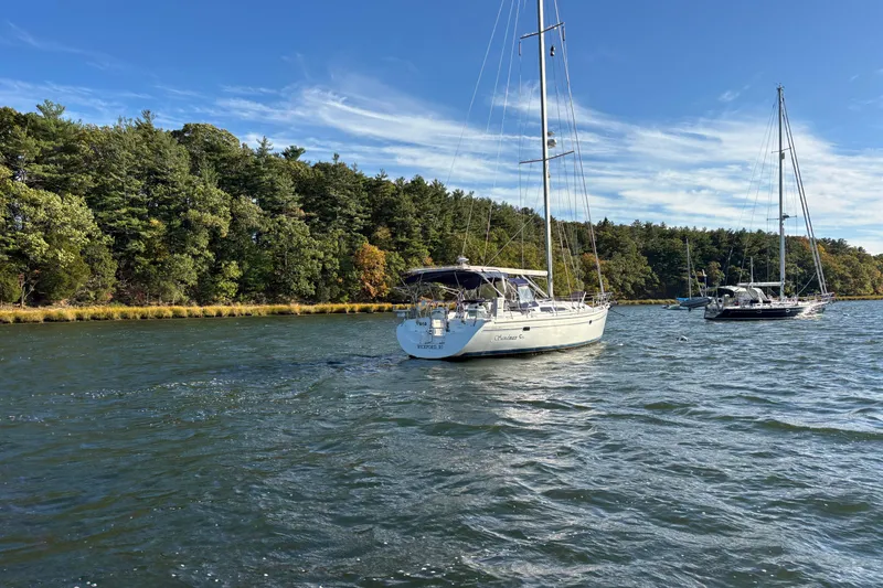 Slide: The Image of Sailboats on a scenic lake, featuring a 2004 Catalina 400 MkII, surrounded by lush trees. - 29