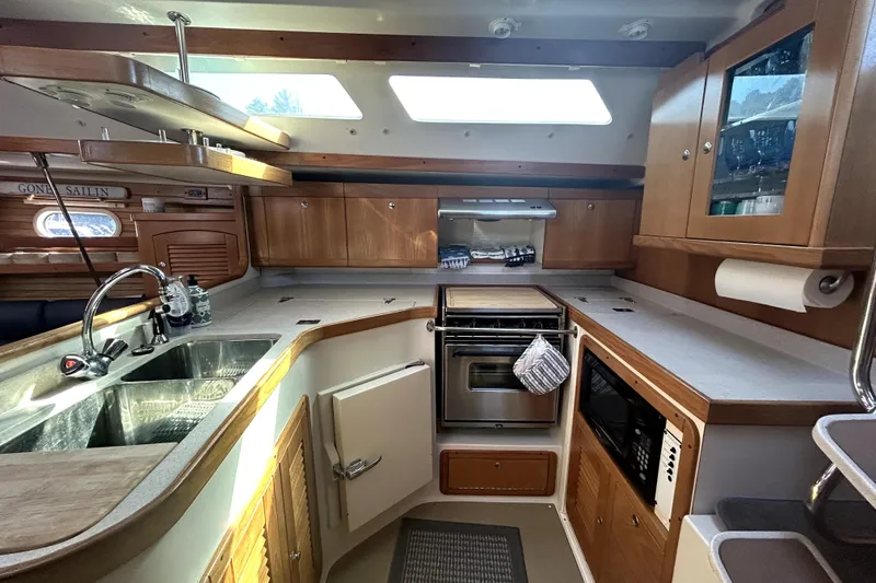 Slide: The Image of Interior of 2004 Catalina 400 MkII yacht kitchen with modern amenities and wooden cabinetry. - 8