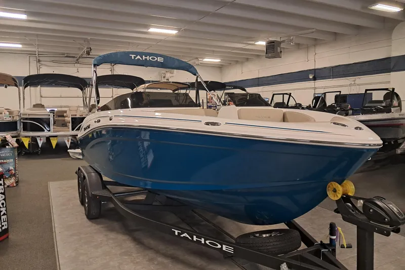 Slide: The Image of 2026 Tahoe 210 S boat in showroom, blue hull, on trailer, indoor display. - 3
