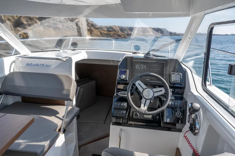 Slide: The Image of 2025 Beneteau Antares 8 cockpit with modern steering and navigation system, cruising on open water. - 3