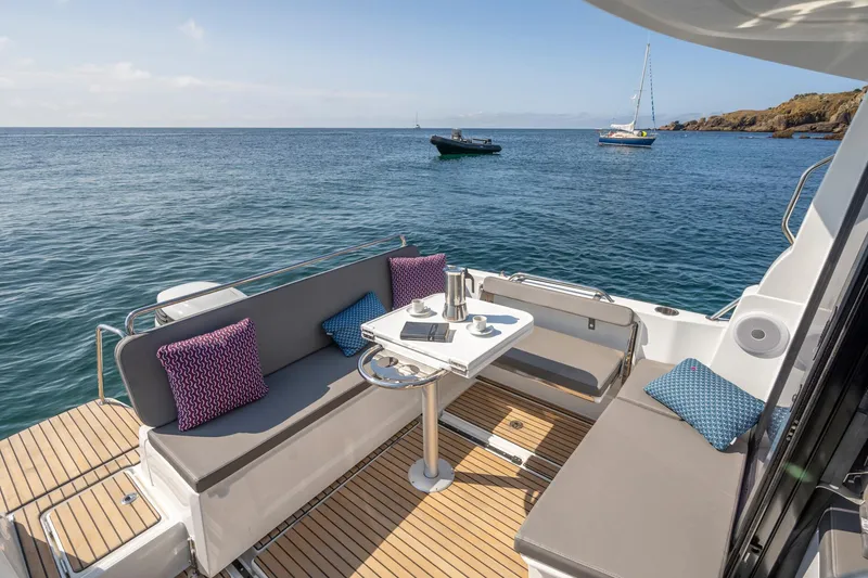 Slide: The Image of 2025 Beneteau Antares 8 boat with cozy seating area on calm sea. - 8