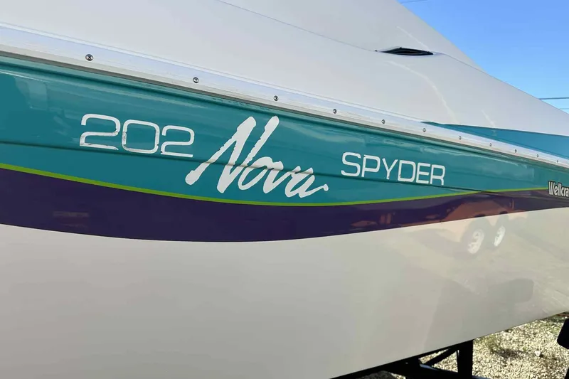 Slide: The Image of 1993 Nova Spyder 202 boat side view with teal and purple accents. - 6