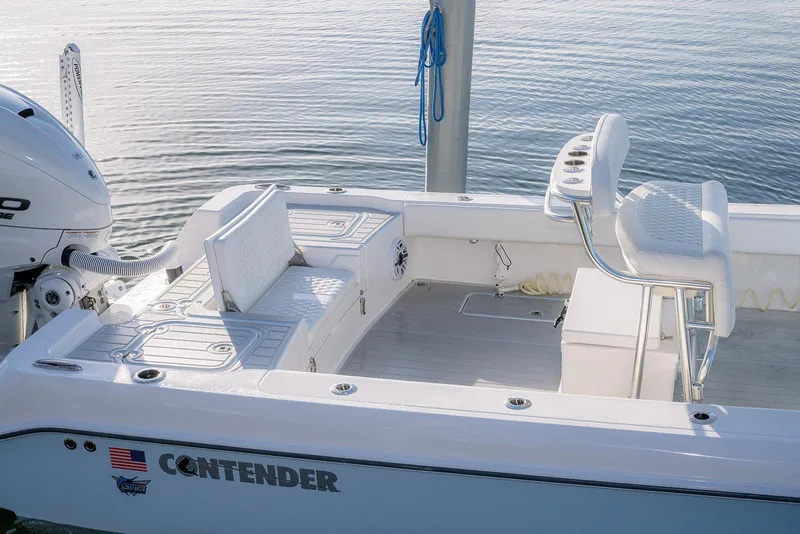 Slide: The Image of 2025 Contender 29 Bay boat interior with seating and motor, docked on calm water. - 18