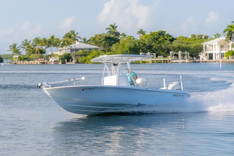 Slide: The Image of 2025 Contender 29 Bay boat cruising on a scenic waterway with palm trees. - 4