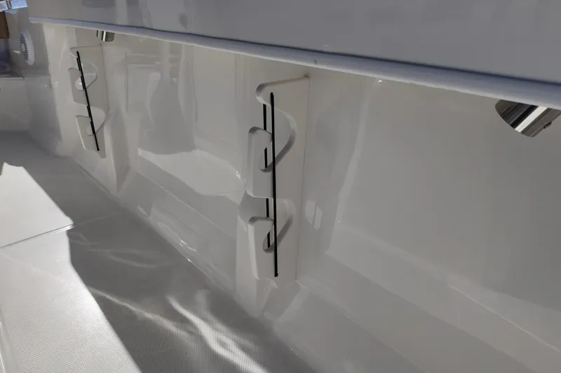 Slide: The Image of 2026 Bayliner Trophy T22CC interior detail with rod holders and sleek design. - 11