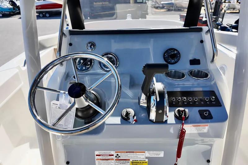 Slide: The Image of 2026 Bayliner Trophy T22CC boat dashboard with steering wheel and controls. - 12