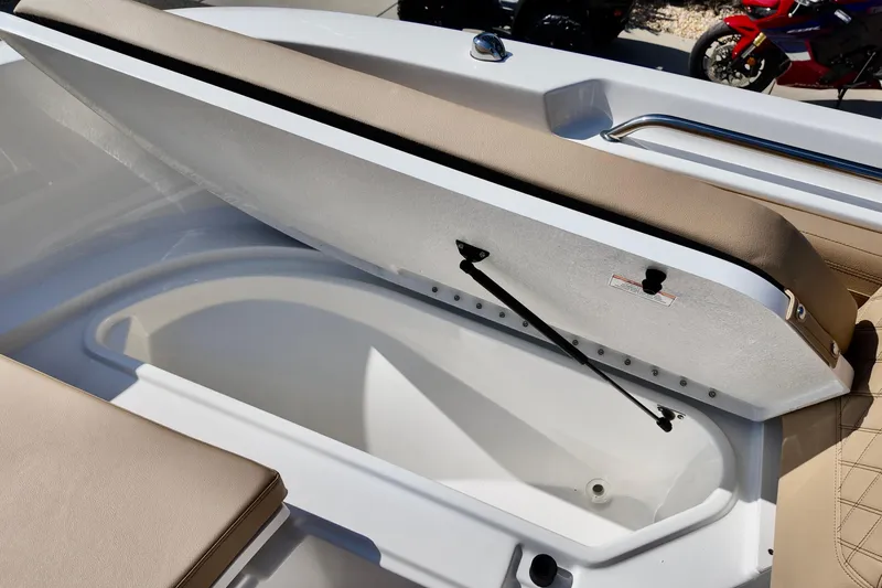 Slide: The Image of 2026 Bayliner Trophy T22CC boat storage compartment with open lid and cushioned seating. - 15